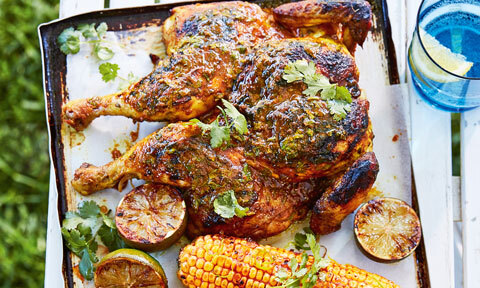 Deliscious whole butterflied BBQ chicken, garnished with coriander sprigs, corn and lime zest. 