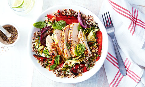 One serve of fresh chicken quinoa salad, garnished with mint leaves.