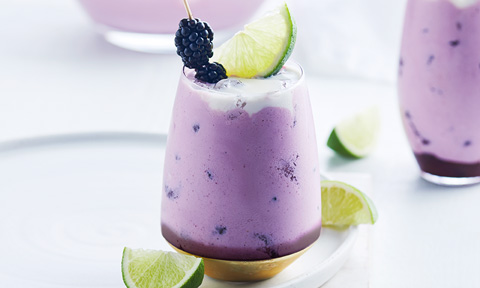 Blackberry and pink gin splice topped with coconut cream and lime slice