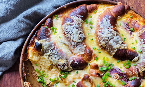 A baked dish with cheese and croissants