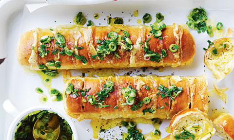 Two garlic baguette with brie on a baking tray