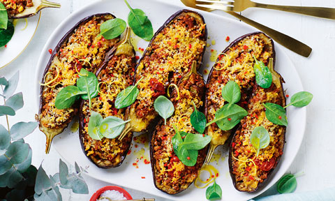 Six lentil-stuffed eggplants on a baking tray