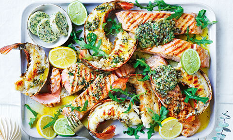 Lobster tails and salmon with horseradish butter, garnished with rocket, lemon and lime.