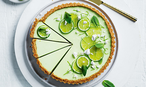Margarita cheesecake tart topped with lime sices and mint leaves