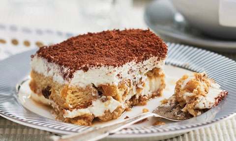 A slice of panettone tiramisu dusted with coco powder