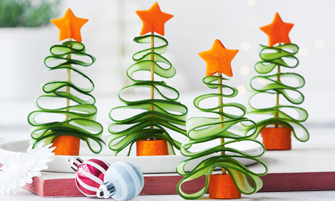 Four veggie Christmas trees made of carrots and cucumber slices