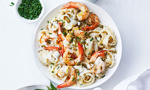 Creamy linguine carbonara with prawns and baby capers, with chopped chives on the side. 