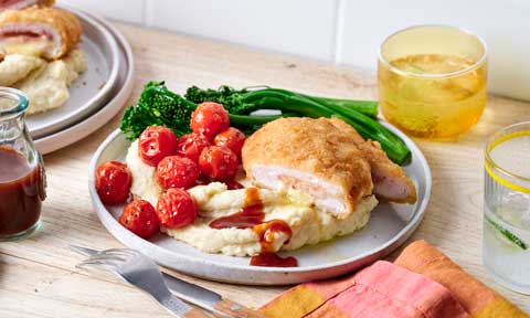 Chicken cordon bleu with hommus mash and roasted tomatoes