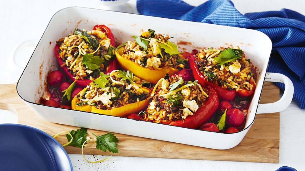 Stuffed side-up capsicums in a roasting pan