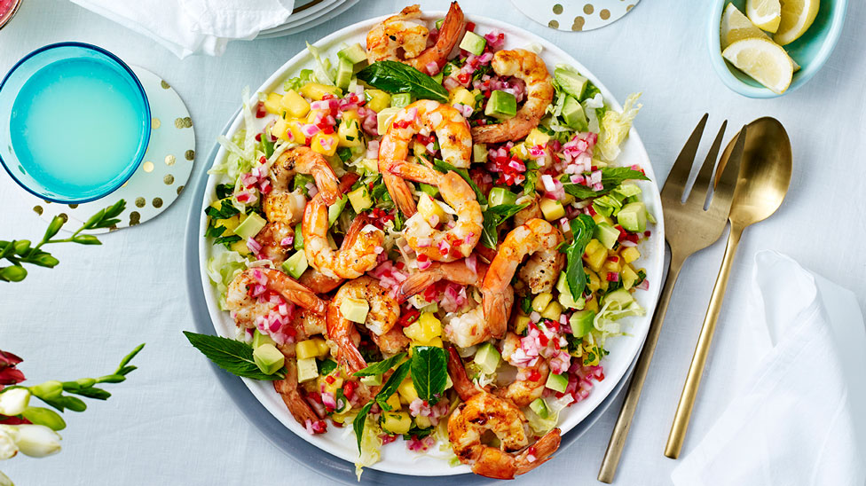 A bowl of barbecued prawns with avocado and mango salad
