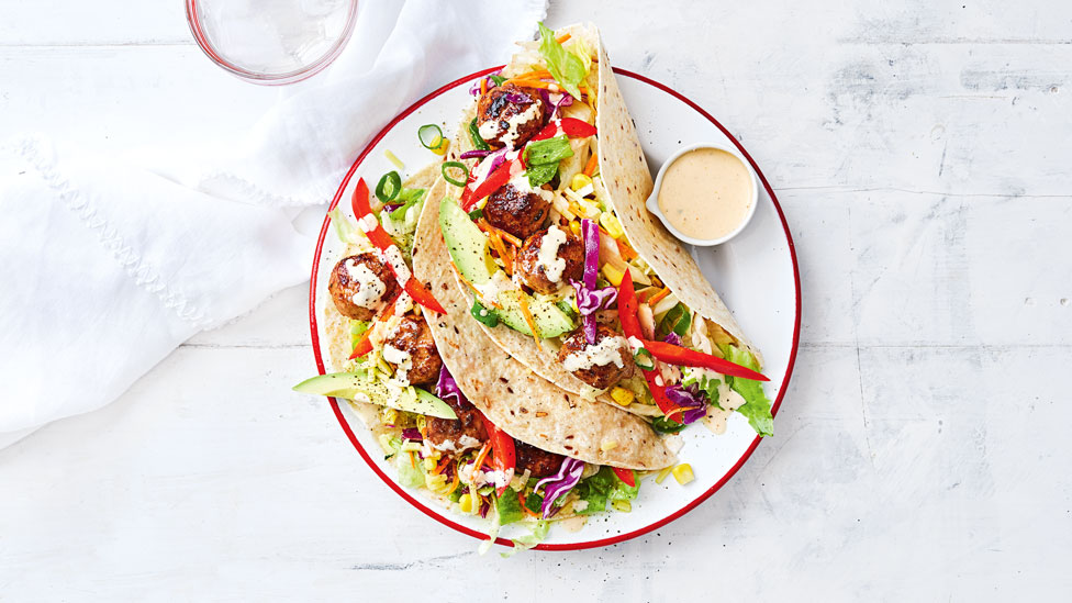 Two open wraps with mexican style meatballs, toppings and cheese