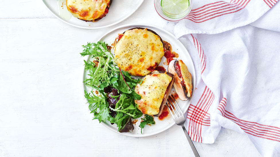 Two mushrooms parmigianas served with a simple salad