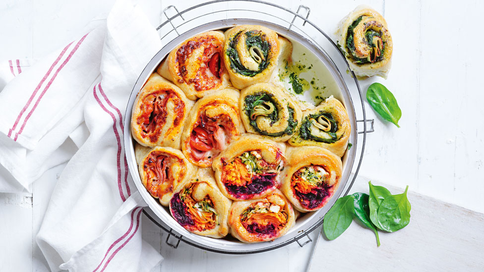 Pull apart sandwiches in a baking dish decorated with some basil