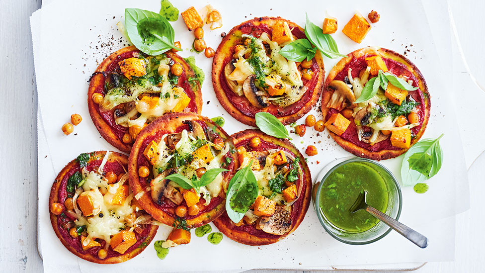 Six pumpkin and chickpea mini vegan pizzas with basil mixture