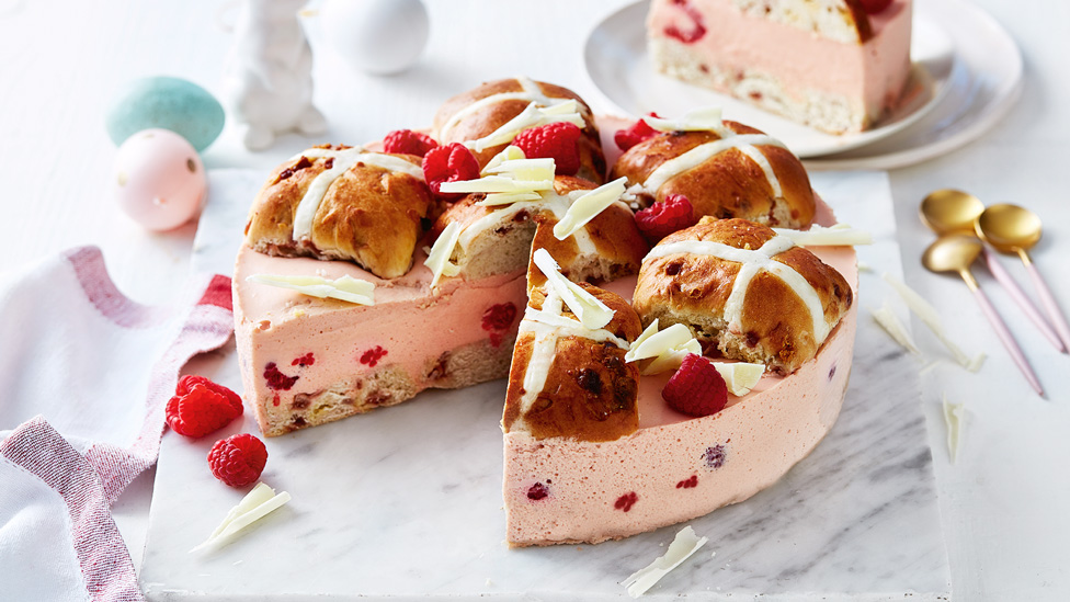 Hot cross buns on top of raspberry and white chocolate cake