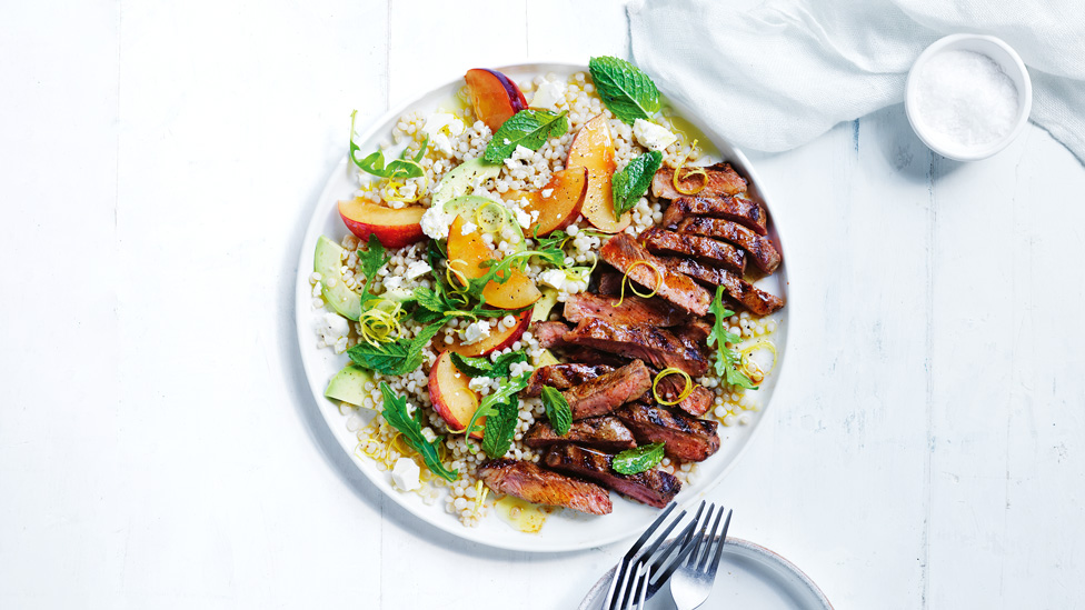 Thickly cut spiced beef steaks with plum and couscous salad