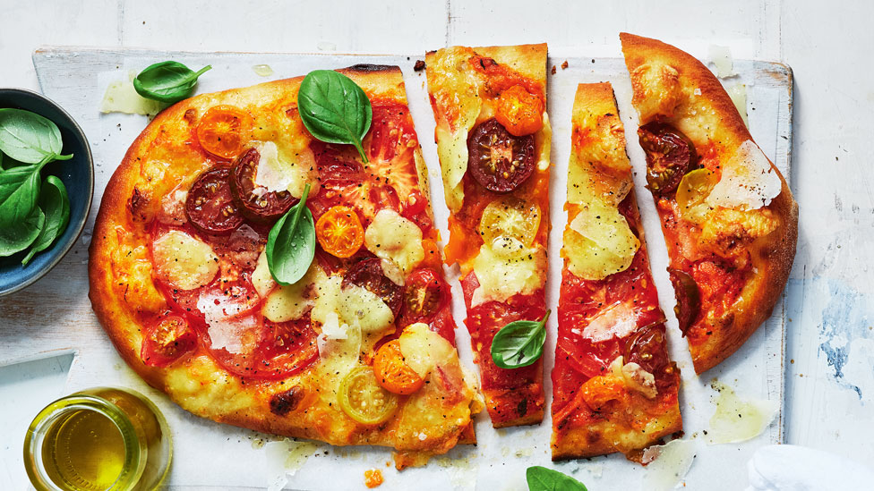 Tomato and bocconcini pizza cut into wedges