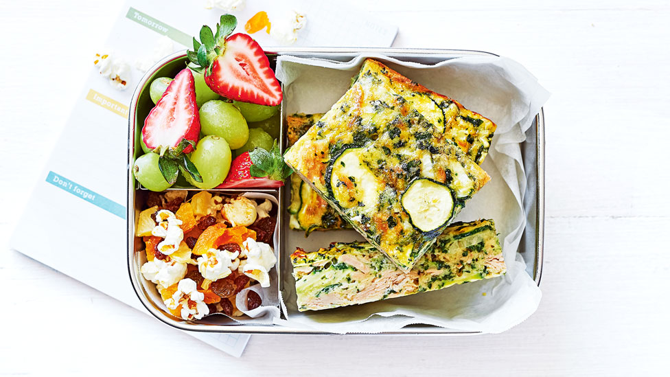 Tuna and zucchini slice in a lunchbox with fruit and granola