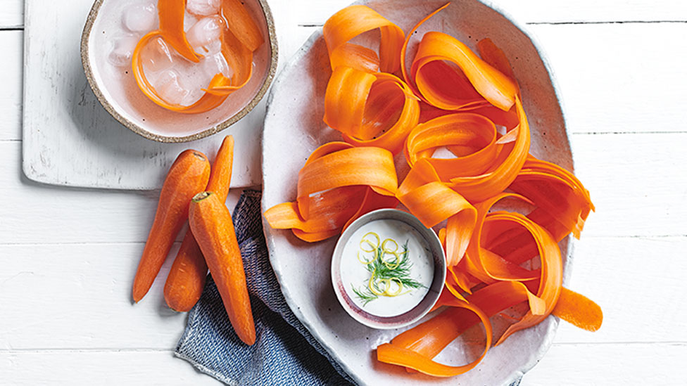 Curly peeled carrots with a creamy dip dish