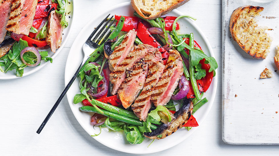 Thickly sliced grilled beef steak with green beans salad