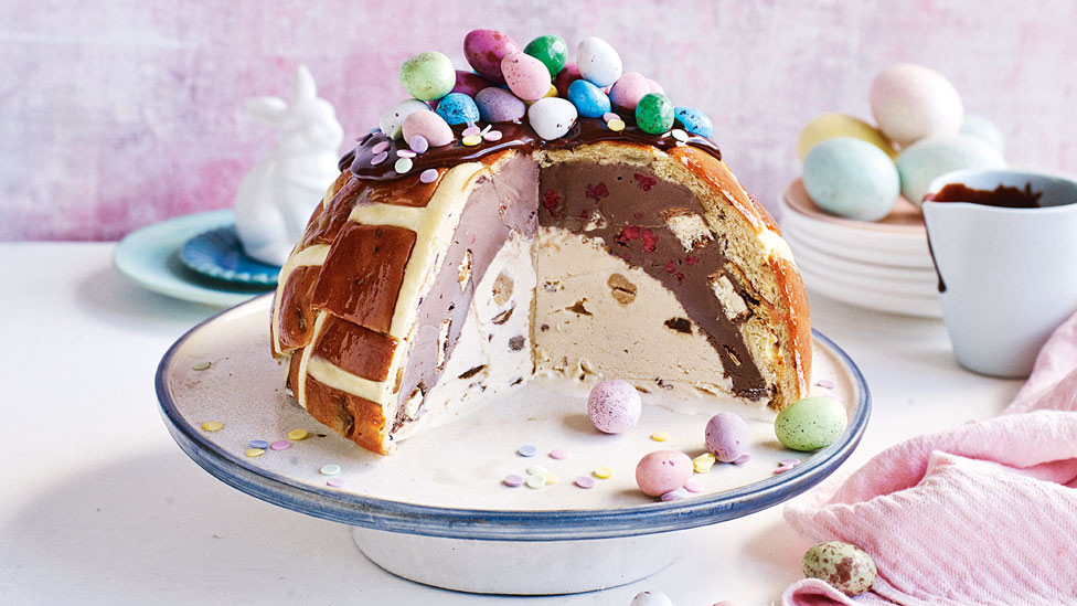Three fourth of a hot cross bun bombe topped with chocolate eggs