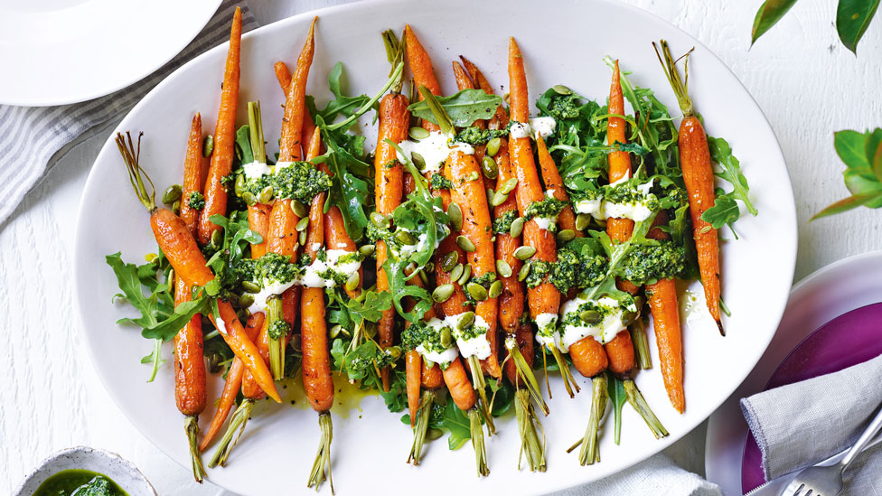 A bunch of roasted carrots with pumpkin seed pesto