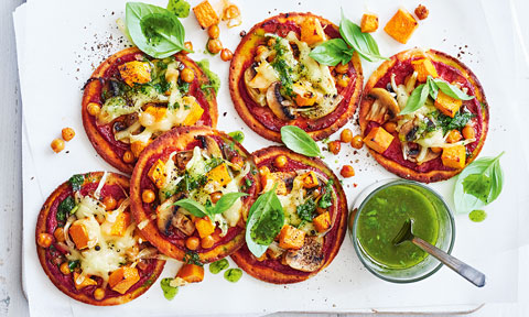 Six pumpkin and chickpea mini vegan pizzas with basil mixture