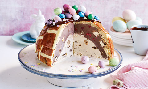 Three fourth of a hot cross bun bombe topped with chocolate eggs