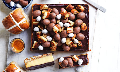 Hot cross bun caramel slice topped with bun top pieces and Easter eggs