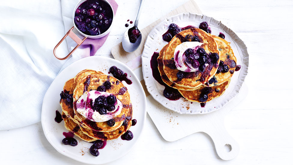 Pumpkin and blueberry pancakes topped with whipped cream and blueberries