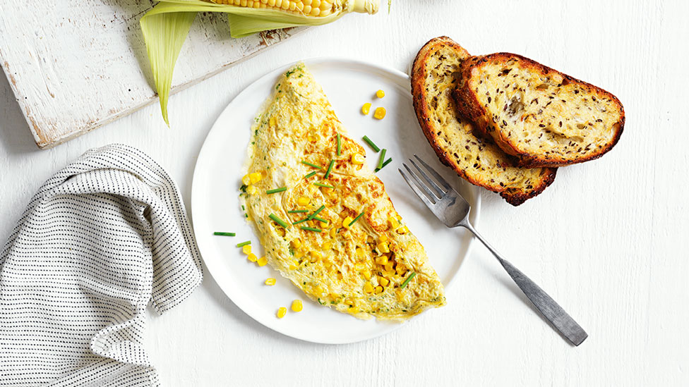 Cheesy omelette filled with corn, chives and cheddar