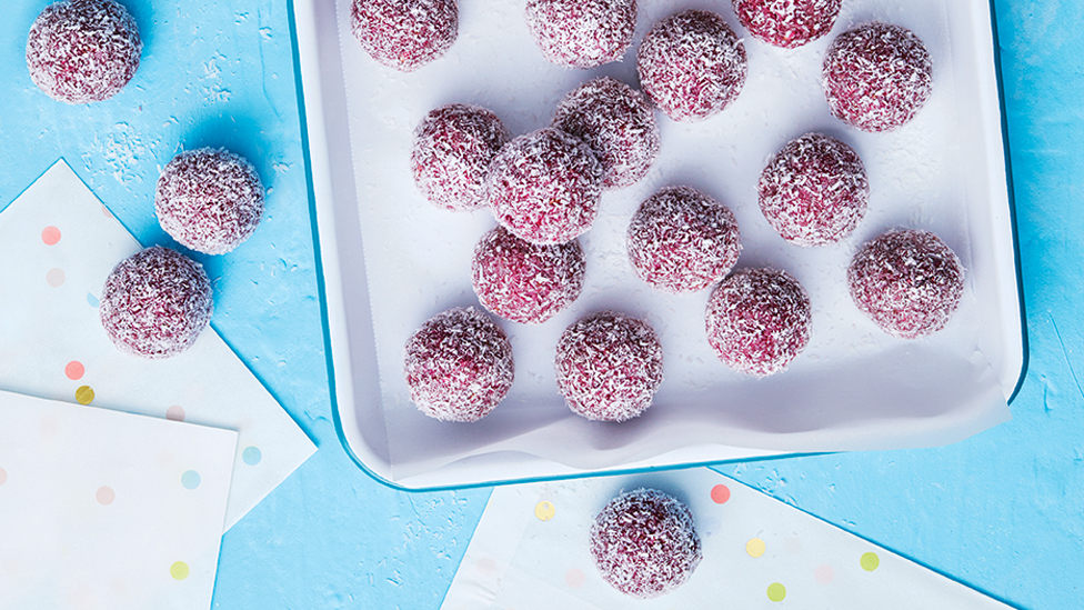 Raspberry bliss balls served on a baking tray