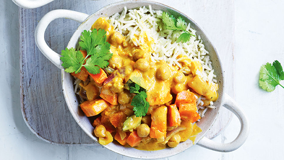 Chickpea curry served in a bowl with rice and coriander on top