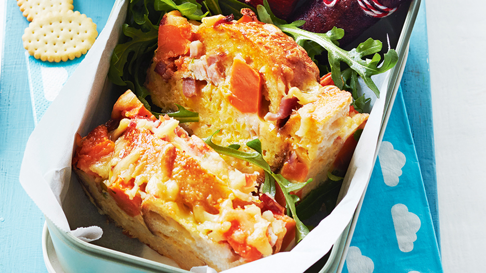 Sweet potato and bacon loaf served in a lunch box with salad greens