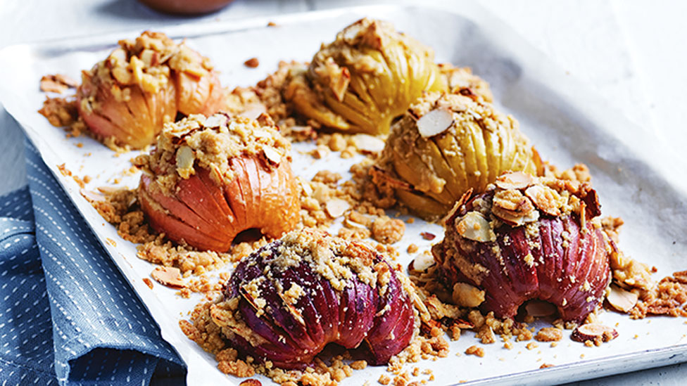 Six baked apples with flaked almonds on top