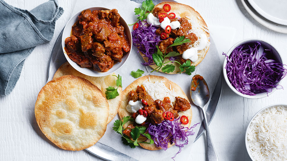 Two madras tostadas with cabbage and chilli on top and extra beef and tostadas on the side 