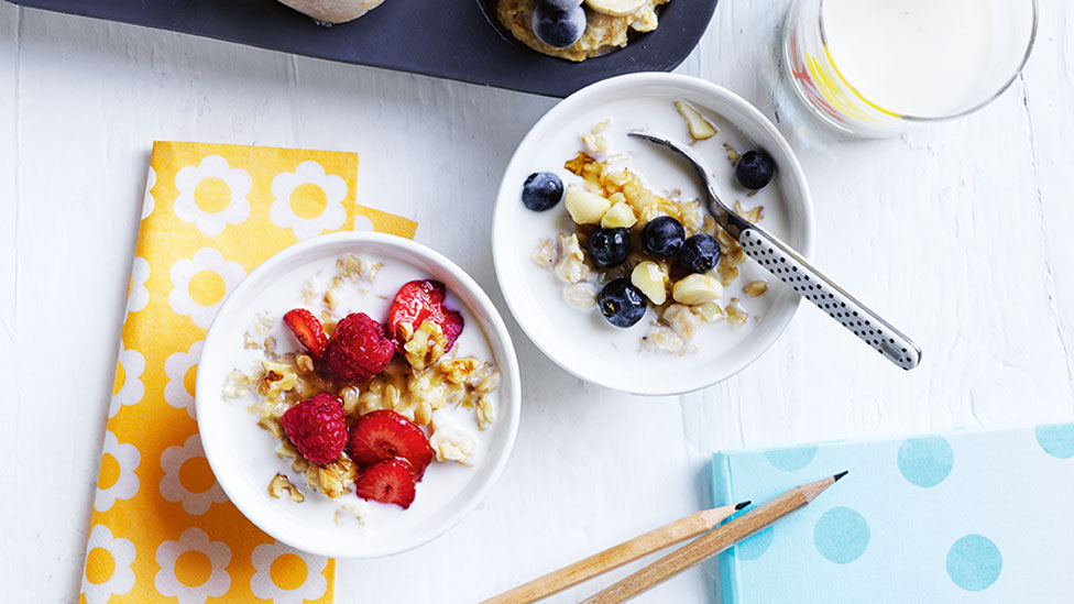 Two bowls of oats with milk and fresh berries on top