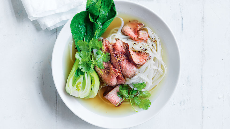 Bowl of beef pho with vermicelli noodles, beef and bok choy
