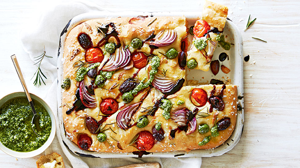 Fresh and savoury tomato and olive focaccia served with pesto on the side