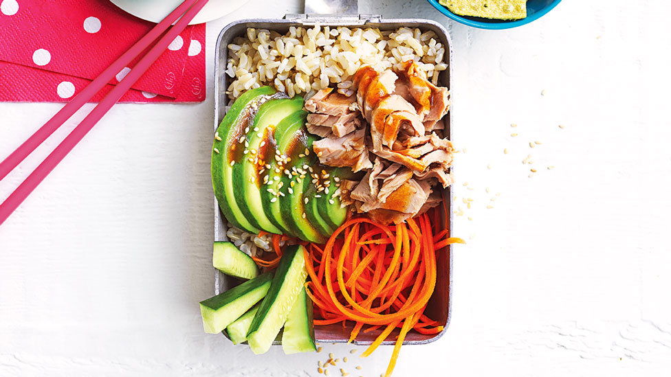 Tuna and rice served in a lunch box with cucumber, shaved carrot and avocado