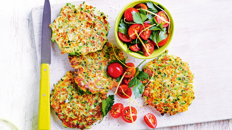 Four zucchini and pea fritters serve with salsa on the side