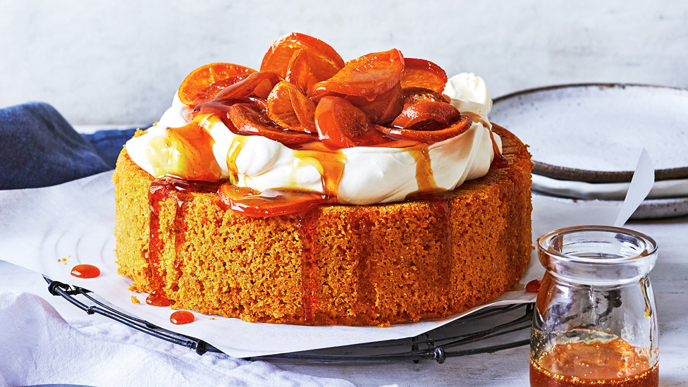 Whole mandarin and almond cake with whipped cream and ornages on top