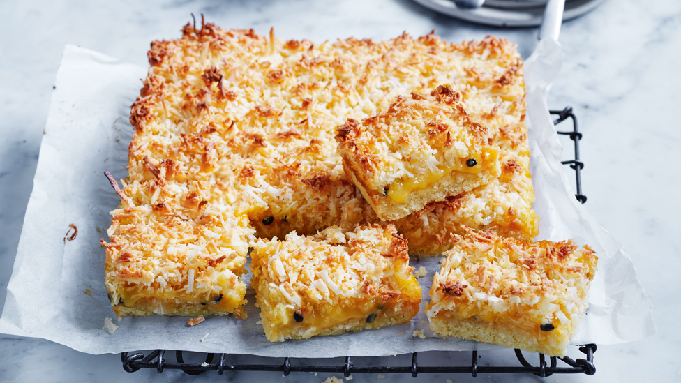 Slices of passionfruit coconut slice arranged on a baking tray