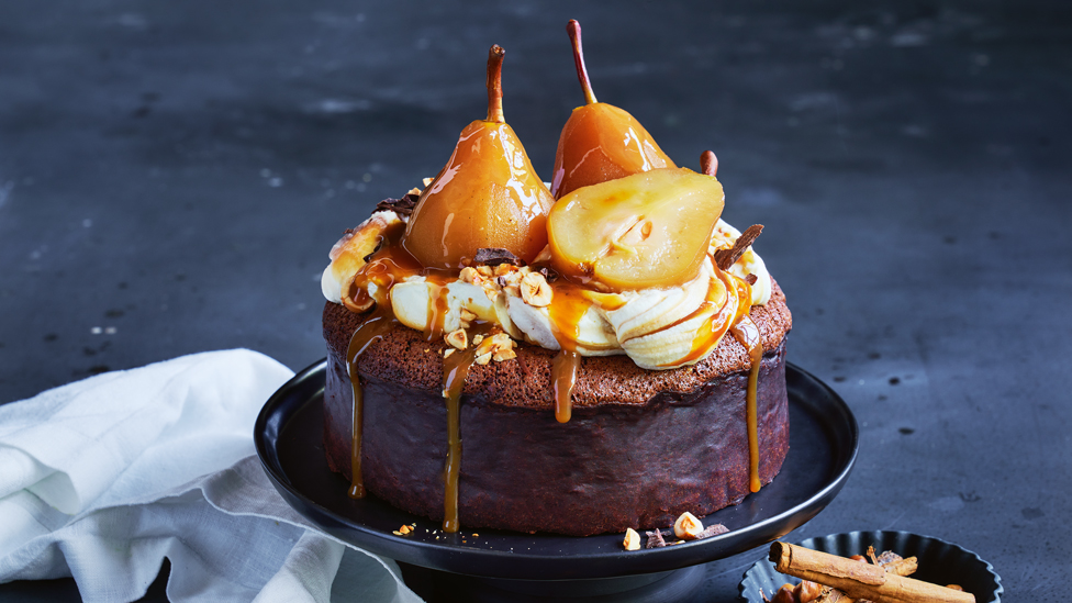 Whole sticky pear chocolate mud cake with whipped cream, caramel and two whole pears on top