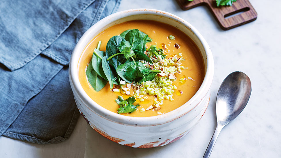Sweet potato soup served a bowl with spinach and sambal on top