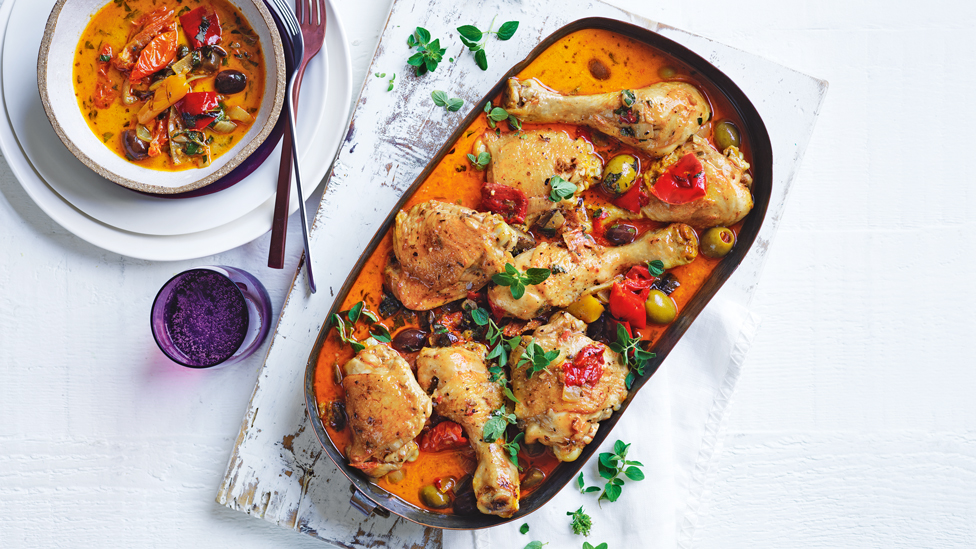 Chicken in a baking dish with capsicum, olives and parsley on top
