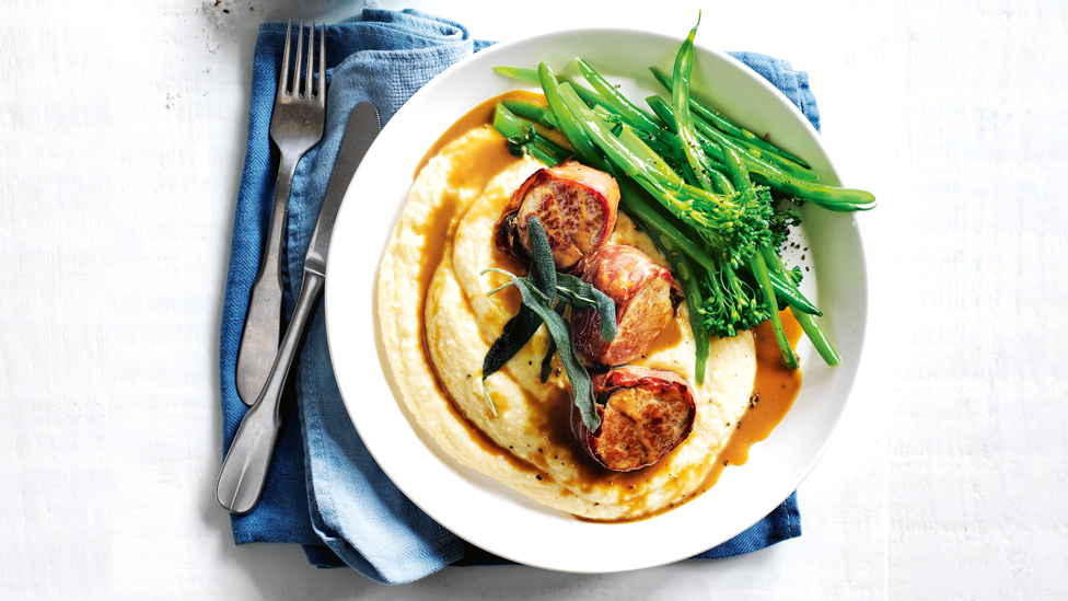 Prosciutto-wrapped pork fillets served on top of polenta with broccoli and mustard sauce