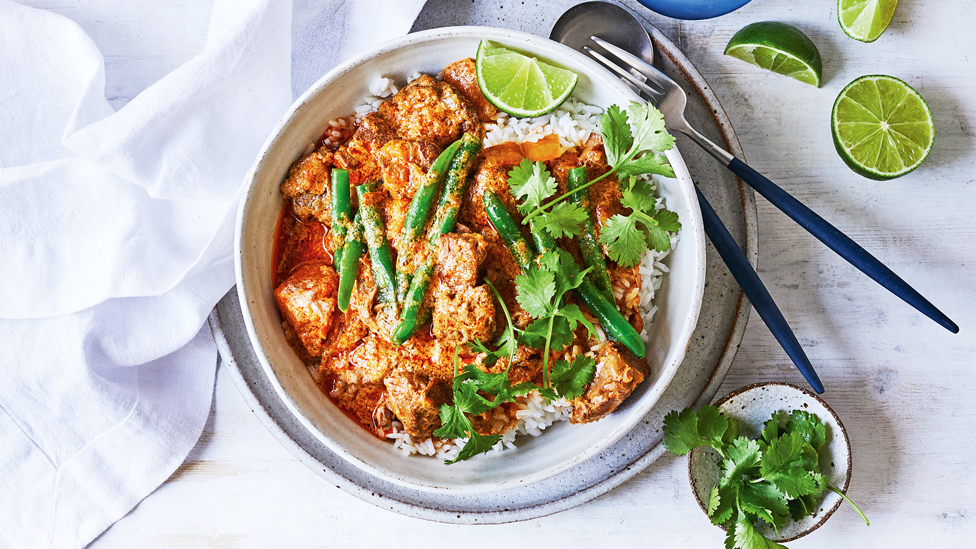 Red curry pork served on top of rice with green beans and coriander 