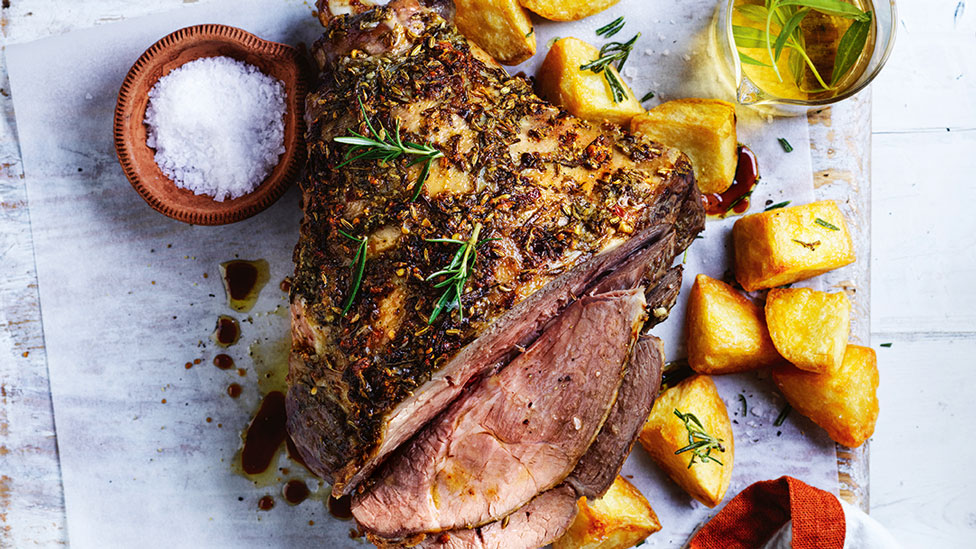 Roast lamb with crispy potatoes served alongside a dish of salt and rosemary olive oil