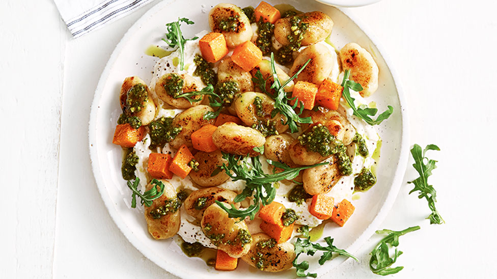 Gnocchi with pumkin and pesto served on top of whipped ricotta